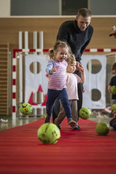 Mand og to børn leger med bolde