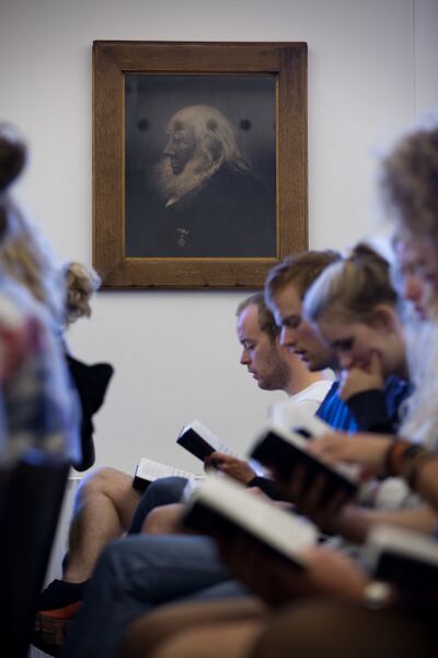 Syngende unge siddende under billedet af Grundtvig