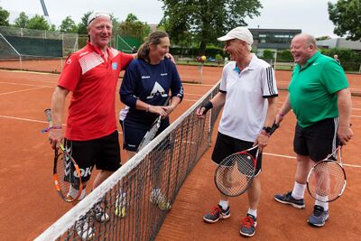 Fire ikke-unge tennisspillere har det sjovt ved nettet på tennisbanen